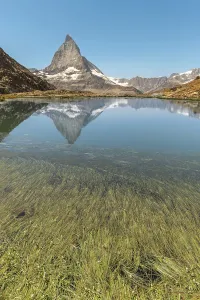 The sharp peak of Matterhorn rises majestically above a serene alpine lake