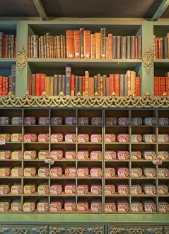 Shelf with antique books and colourful tins