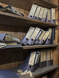 Shelves with dusty folders in the administration of a former GDR factory