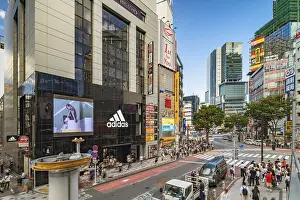 Shibuya Crossing Intersection in front of Shibuya Station on a bright day blue sky
