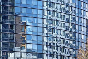 The shimmering blue, rounded, glass facade of a modern office tower