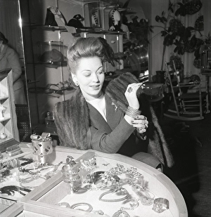 Shopping in the 1940s. A young woman in a store with a selection of jewellery and charms
