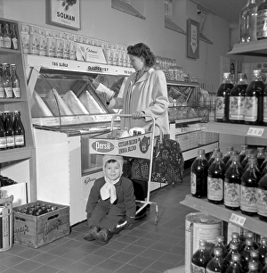 Shopping in the 19502. A woman shops in a self service store. Both the idea of self service and the shopping trolley came from America and aimed to encrease sales