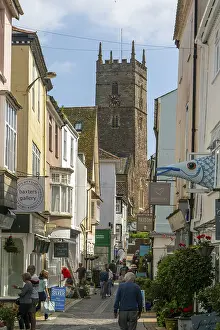 Shops in historic buildings along alleyway with tower of church of St Saviour