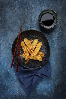 Shrimp in tempura, deep fried, on a black plate