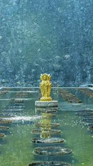Four sided standing Buddha statue in man made pond at Buddhist temple in Yeongcheon