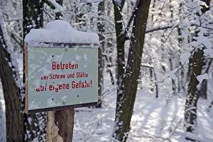 Sign covered in snow, warning of snow and ice