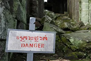 Sign "Danger" warns of climbing in the ruins of Preah Paliliay tempel in the ancient city Angkor Thom