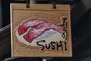 Signboard with inscription Sushi in front of a restaurant