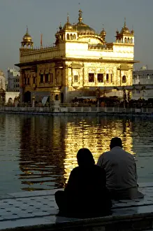 Sikh sitting on the marble steps of Amrit sarovar the lake of nectar
