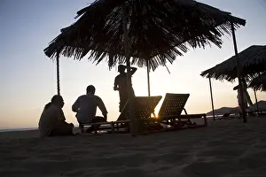 Silhouette human figure and shelter against blue sunset