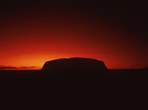 Silhouette outline of Ayers Rock or Uluru in red sunrise or sunset