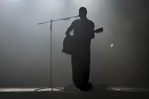 Silhouette of rock star with guitar on the stage in Lubin