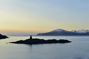 Silhouette of a small island with a lighthouse in the evening