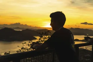 Silhouette of a tourist leaning on a railing