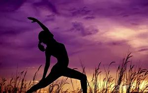Silhouette of young woman doing yoga at outdoor park