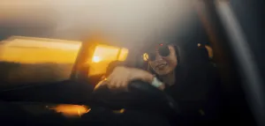 Silhouetted woman in a car at sunset
