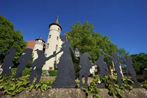 Silhouettes of Snow White and the Seven Dwarfs in front of a castle with round towers