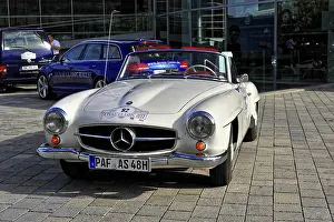 Silver Mercedes-Benz vintage convertible in sunlight on cobblestones
