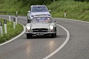 Silver Mercedes classic car on a country road with an SUV in the background