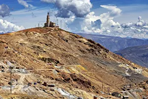 Framed Print : Single building with antennas on a bare hill under a dramatic sky