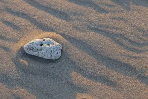 A single stone on the sandy beach