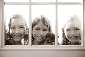 Three sister friends looking through the window with a pup and raindrops
