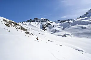 Ski tourer in mountain landscape with snow