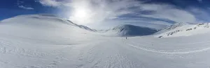 Ski tourer with pulka in the snow