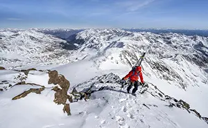 Ski tourers on foot, carrying skis on a rucksack