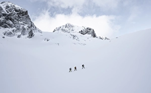 Three ski tourers in a lonely landscape