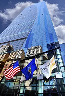 Skyscraper facade with flags and reflection in the glass facade