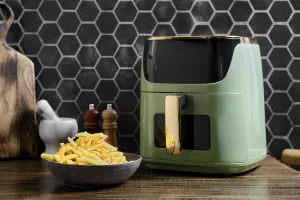 A sleek air fryer is on a wooden countertop in a contemporary kitchen