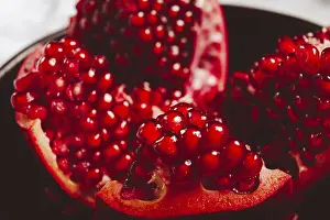 Sliced fresh pomegranate, on a black plate