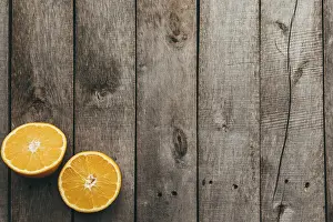 Sliced halves of orange fruit on gray wooden background