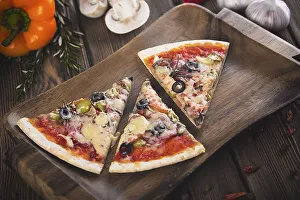 Sliced tasty fresh pizza with mushrooms and sausage on a wooden background