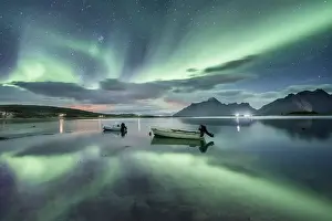 Small (Aurora borealis) motorboats anchoring in a bay