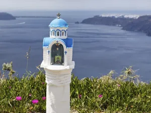 Small blue and white chapel with a view of the caldera
