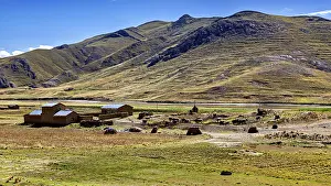 Framed Print : Small houses at the foot of mountains in a vast landscape under blue sky