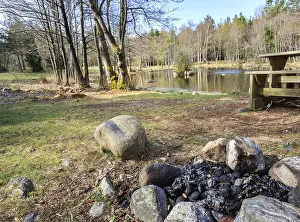 Small lake with campfire and bench in Jomfruland National Park