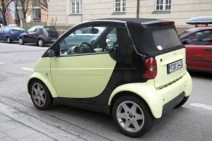 Small light green color smart car parked on the street