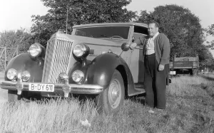 Small man, large car, historic photograph