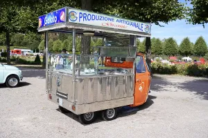 Small orange vending cart with open gelato area in a park