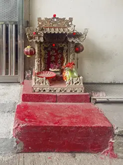 A small roadside red colored buddhist temple in Hong Kong