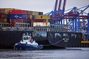 Small tug VB Perfect with large container ship MSC Tokyo at the Burchardkai container terminal in the Port of Hamburg
