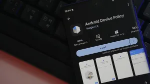 Smartphone app store screen displaying Android Device Policy ready to install on keyboard