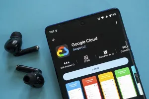 Smartphone displaying Google Cloud app with black earbuds against blue background