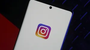 Smartphone displaying Instagram logo on screen over dark background