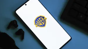 Smartphone showing Warner Bros logo with earphones on a blue background
