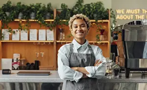 Smiling confident coffee shop owner at the counter